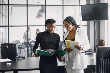 business women talking near desk during coffee break hallway big corporation